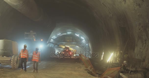 Byggnadsarbetare inuti en stor tunnel under konstruktion — Stockvideo