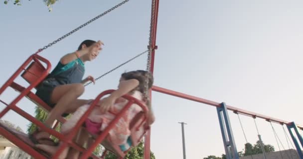 Niños felices balanceándose en swing — Vídeo de stock