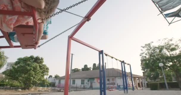 Niños felices balanceándose en swing — Vídeo de stock