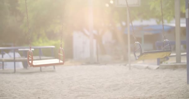 Пустые качели на детской площадке — стоковое видео