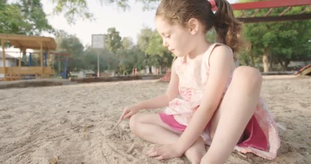 Nettes kleines Mädchen zeichnet auf Sand — Stockvideo