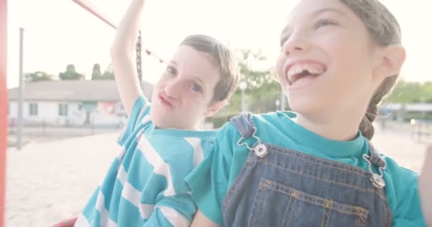 Діти гойдаються на гойдалках — стокове відео