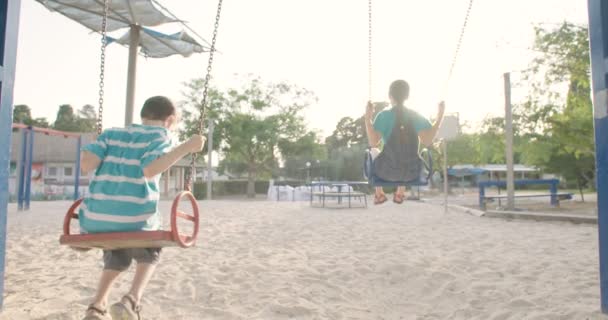 Les enfants balançant sur swing — Video