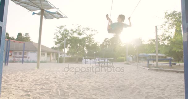 Niños balanceándose en swing — Vídeo de stock