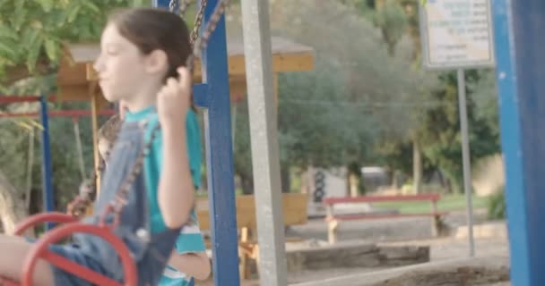 Діти гойдаються на гойдалках — стокове відео