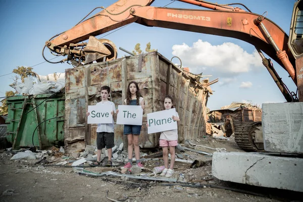 Gezegeni kurtarmak. küçük çocuklar büyük bir hurdalıkta ayakta elinde