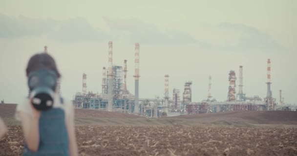 Salva el planeta. Niños con máscaras de gas cerca de una refinería de petróleo — Vídeos de Stock