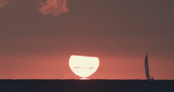 Puesta de sol sobre el mar con una silueta de velero, imágenes de súper teleobjetivo — Vídeos de Stock