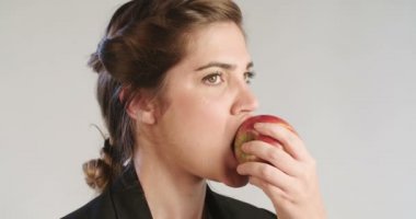 Bir beyaz stüdyo arka plan üzerinde büyük bir Kırmızı elma yemek kadın