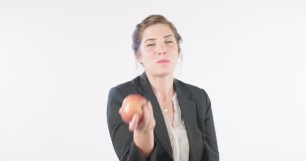 Mulher comendo uma maçã vermelha em um fundo de estúdio branco — Vídeo de Stock