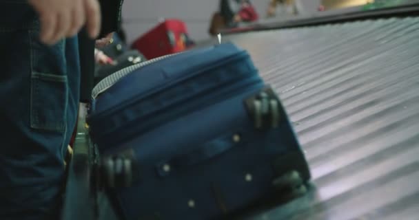 Passengers collecting luggage from a conveyor belt at the airport — Stock Video