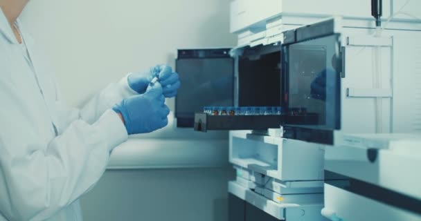 Técnico de laboratorio que trabaja con botellas pequeñas — Vídeo de stock