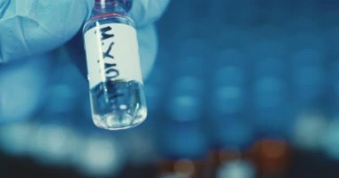 Küçük şişeleri ile çalışan laboratuvar teknisyeni