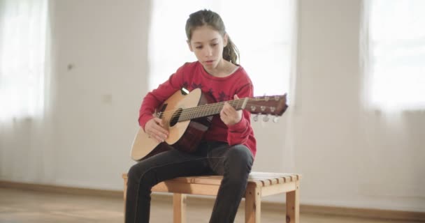 Νεαρό κορίτσι παίζει κιθάρα και το τραγούδι — Αρχείο Βίντεο
