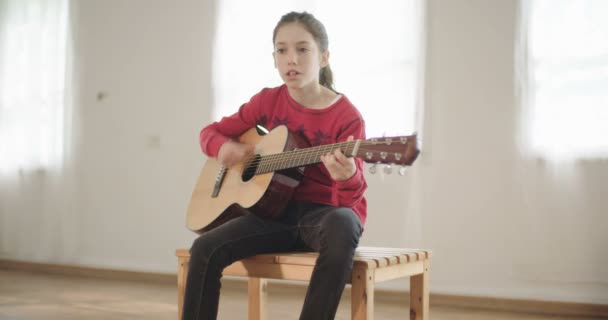 Junges Mädchen spielt Gitarre und singt — Stockvideo