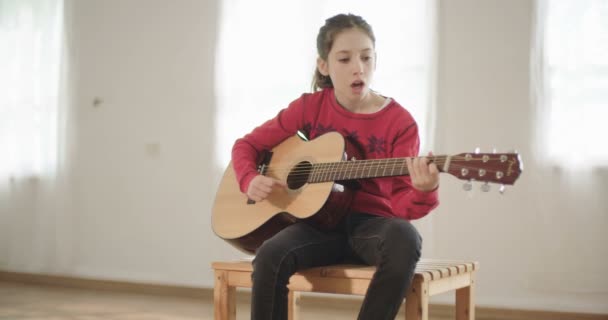 Young girl playing guitar and singing — Stock Video