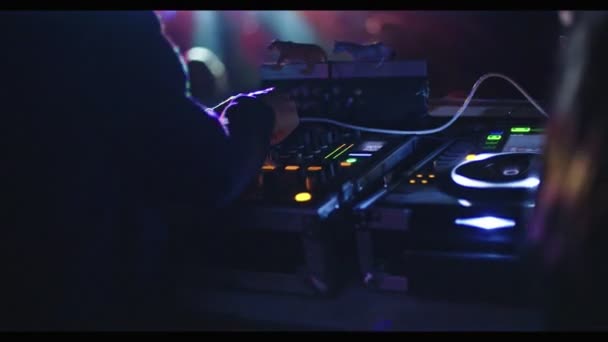 DJ играет в большой транс-вечеринке с большой толпой танцующих — стоковое видео