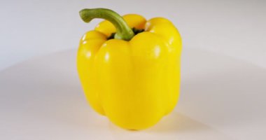Beyaz arkaplanda dönen sarı dolma biberi kapat