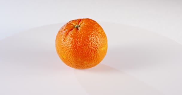 Zbliżenie pomarańczy obracającej się na białym tle — Wideo stockowe