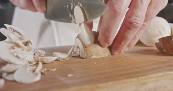 Primer plano de un cuchillo de chef rebanando champiñones champiñones — Vídeos de Stock
