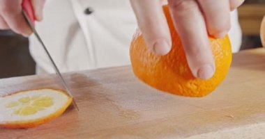 Bir şef bıçağının portakalı soyup doğraması.