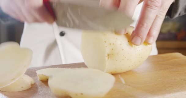 Movimento lento di uno chef affettare una patata con un coltello affilato di grandi dimensioni — Video Stock