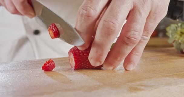 Gros plan d'un couteau de chef tranchant une fraise — Video