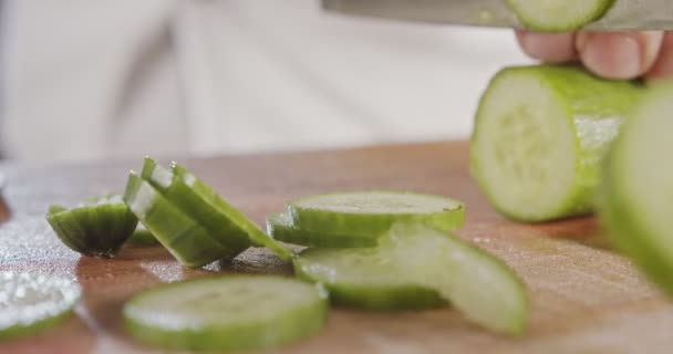 Büyük bir şef bıçağının salatalığı dilimlerken makro çekimi. — Stok video