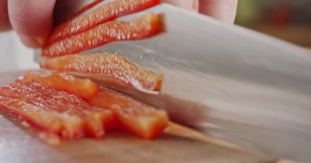 Makro ekstrem pisau koki yang mengiris paprika merah — Stok Video