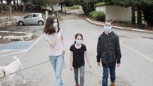 Koronavirová pandemie - děti chodí venku s obličejovými maskami, aby se vyhnuly koroně — Stock video