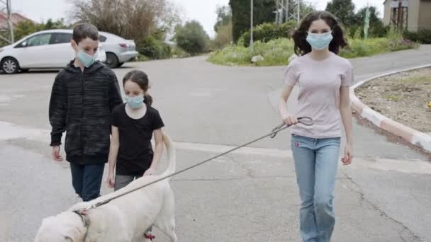 Pandemia de Coronavirus - niños caminando al aire libre con máscaras faciales para evitar la corona — Vídeo de stock