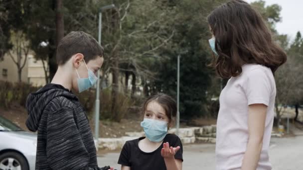 Coronavirus pandemi - barn går utomhus med ansiktsmasker för att undvika korona — Stockvideo