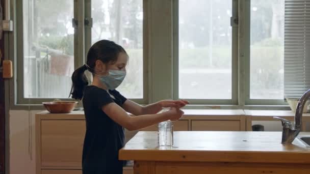 Korona pandemie Dívka s obličejovou maskou pomocí dezinfekce rukou, aby se zabránilo koronaviru — Stock video