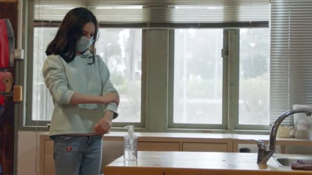 Pandemia Corona Dziewczyna z maską twarzy za pomocą środka do dezynfekcji rąk, aby zapobiec koronawirusowi — Wideo stockowe