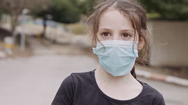 Пандемия коронавируса закрывает лицо девушки в маске, чтобы избежать заражения — стоковое видео