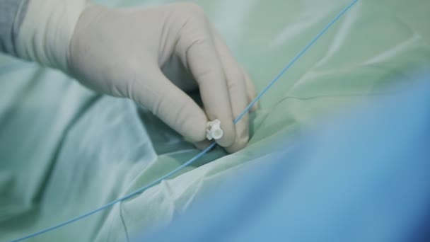 Primer plano en la mano del cirujano durante un cateterismo cardíaco — Vídeos de Stock