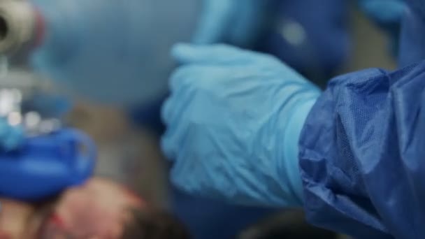 Врачи и медсестры лечат раненого пациента в стационаре скорой помощи — стоковое видео