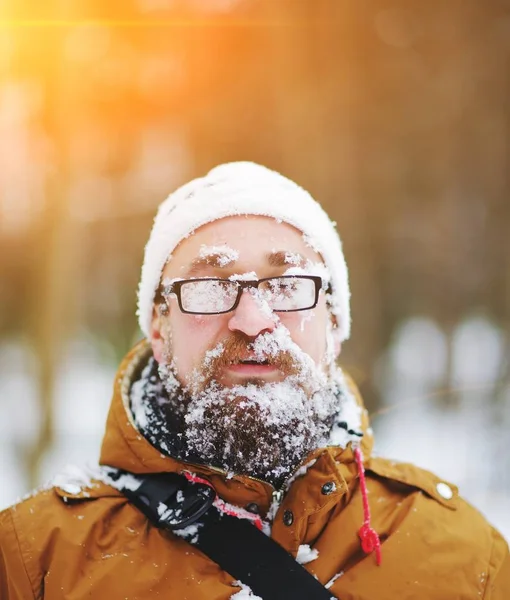 Portrait of bearded man with snow on his face.