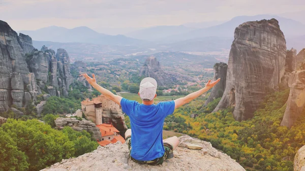 Ο άνθρωπος να σηκωθεί στο χέρι και να κάθεται στην κορυφή του βουνού απολαμβάνοντας ειρηνικά — Φωτογραφία Αρχείου