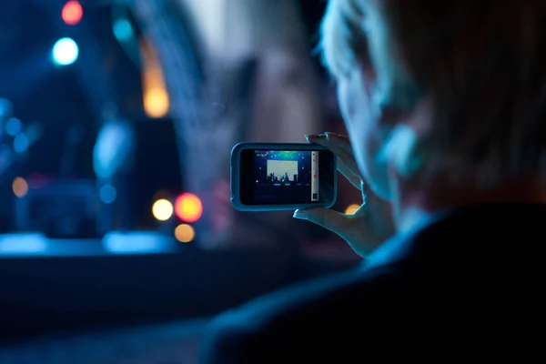 İş kadın alarak fotoğraf bir konserde cep telefonu ile