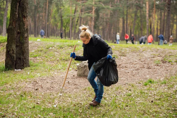 Woman volunteer collecting garbage in park