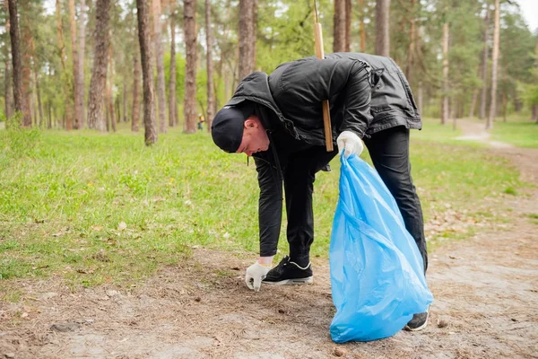 Hombre voluntario recogiendo basura en el parque — Foto de Stock
