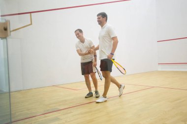 İki adam squash oynuyor.