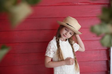 Kızıl saçlı kız beyaz bir şapka kırmızı ahşap duvar arka plan üzerinde elbise