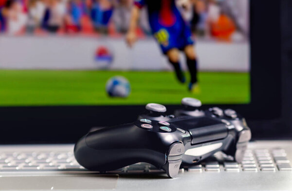 Video game controller isolated on laptop. The black gamepad lies on the laptop keyboard. Game controller with a laptop. 