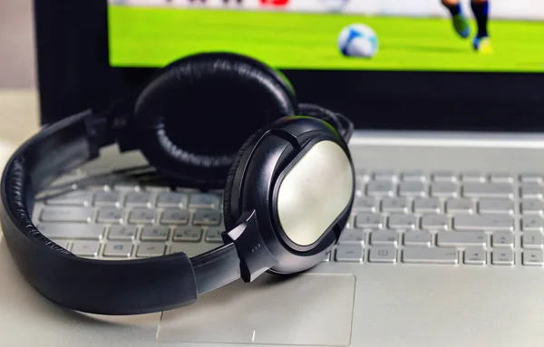 Kulaklıklar laptopta. Büyük siyah kulaklıklar. Kulaklıklar kapalı. Bilgisayar klavyesindeki kulaklıklar. Bilgisayar oyunu duraklatılıyor