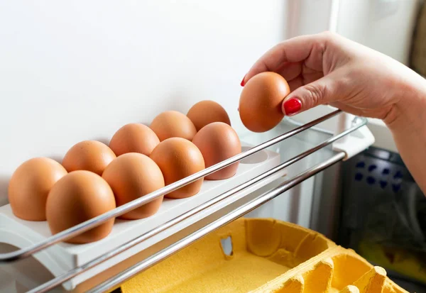 冷蔵庫の段ボールパッケージから鶏の卵の手動コレクション 有機鶏の卵は冷蔵庫で新鮮なまま トレイの中の茶色の卵 有機鶏の卵は冷蔵庫で新鮮なまま — ストック写真