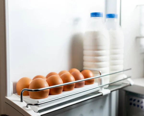 ドアの冷蔵庫の牛乳と卵 有機鶏の卵は冷蔵庫で新鮮なまま トレイの中の茶色の卵 有機鶏の卵は冷蔵庫で新鮮なまま — ストック写真