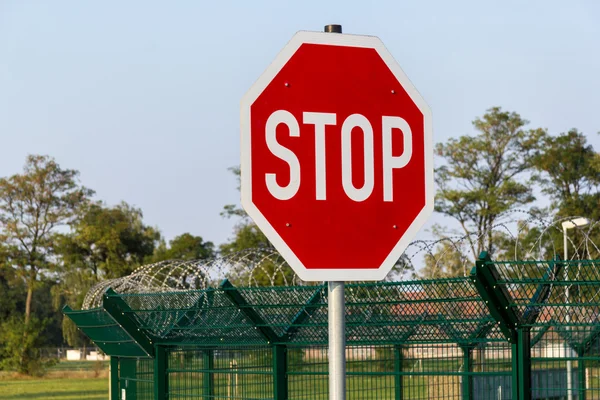 Letrero de stop alemán en cerca de alambre de púas — Foto de Stock