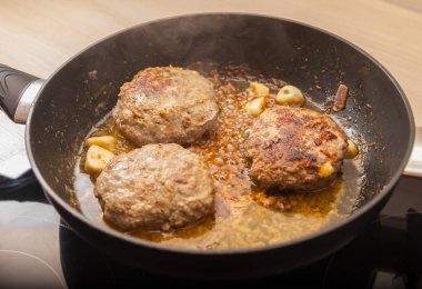 Üç et burger patates bir tavada